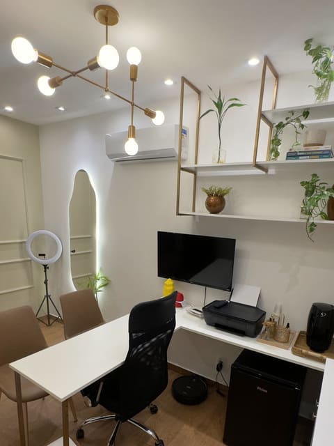 Lustre dourado, espelho iluminado e a bancada de atendimento